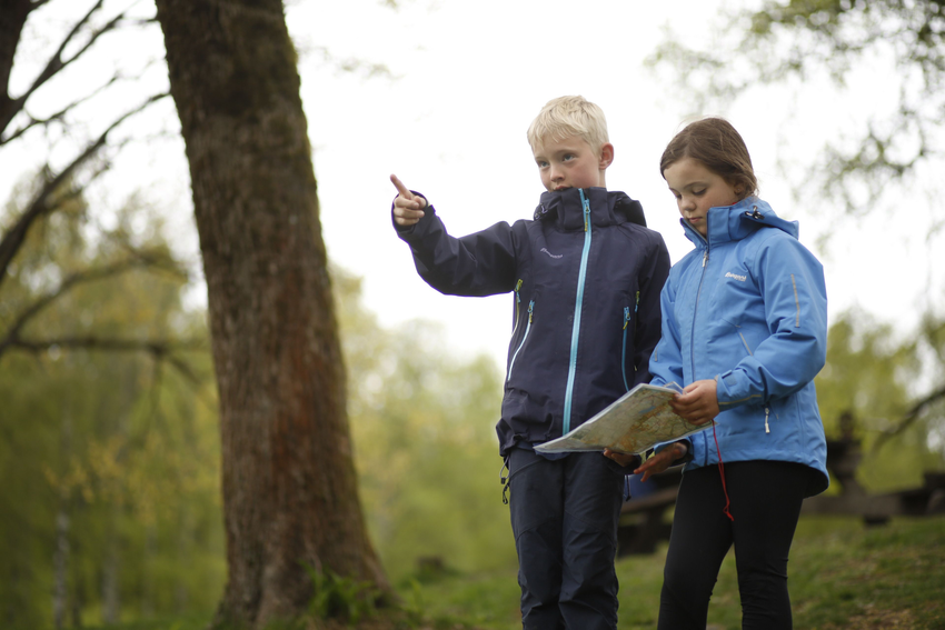 Berniukas ir mergaitė, laikantys orientavimosi sporto žemėlapį
